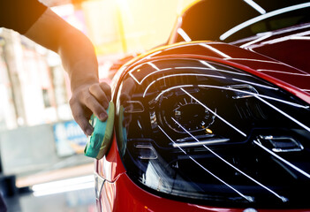 Car service worker applying nano coating on a car detail