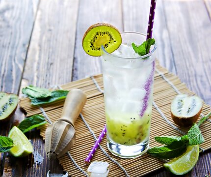 Soft drink, non-alcoholic cocktail with kiwi, lime juice, sparkling water and ice in a tall glass
