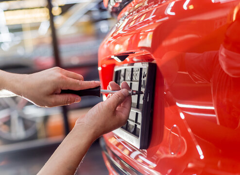 Technician changing car plate number in service center.