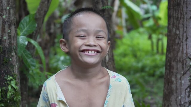Video Portrait of a Handsome Toothless Asian Filipino Kid Smiling into the Camera from the Rural Village in the Philippines with Cheerful Happiness