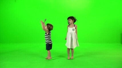 Two cute little kids dancing and playing around happily over green screen. - Powered by Adobe