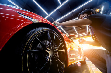 Car service worker applying nano coating on a car detail