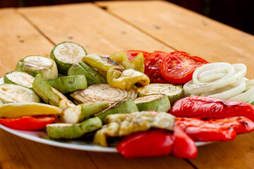 grilled vegetables on a plate. tomatoes with a tender crust. zucchini, onion, pepper