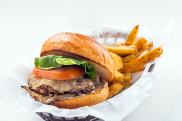 Hamburger consists of tomato and lettuce with french fries meal