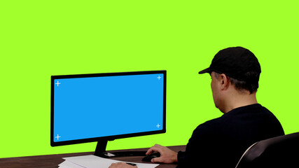 Adult man working on a computer with isolated mockup blue blank screen, Chroma key,