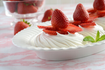 closeup meringue nests with fresh strawberries and mint