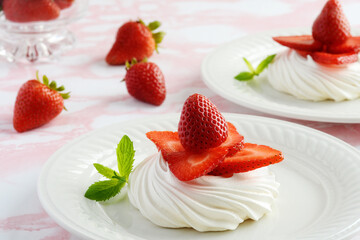 closeup strawberry meringue nests on a plate with mint