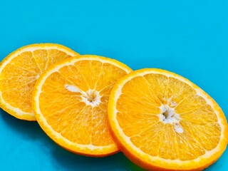 Fresh orange slices on blue background closeup. Flat lay, copyspace, top view.