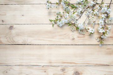 Fototapeta premium White flowers on a wooden background. Flowers are scattered on a wooden table. View from above