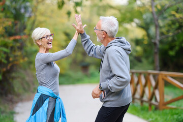 Active senior couple exercising in the park having fun laughing