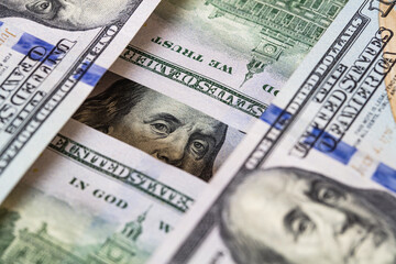 Benjamin Franklin peeking through 100 dollar banknotes