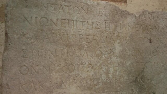 Slow motion close up of ancient greek alphabet letters on stone tablet