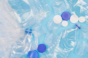 Different plastic garbage on blue background. Plastic waste recycling concept. Ecology and...