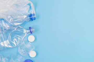Different plastic garbage on blue background. Plastic waste recycling concept. Ecology and environmental care. Top view flat lay with copy space. 