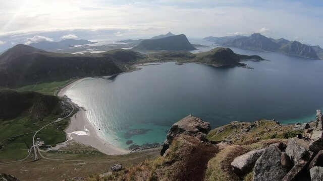 Beautiful view over Haukland beach from mountain Mannen in Lofoten, Norway. Small farms and green fields next to the countryside road.