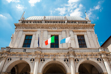 Comune di Brescia - City or town hall of Brescia, Lombardy, Italy. The main Italian landmark with a round roof, white walls, windows, sculptures, flags of European Union. Architecture. Heritage.