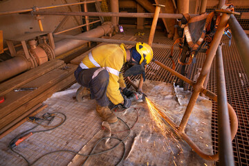 Safety practices construction worker wearing safety hard hat and clear face shield eyes protection while conducting preparation grinding handrail repairing     - obrazy, fototapety, plakaty