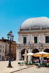 Comune di Brescia - City or town hall of Brescia, Lombardy, Italy. The main Italian landmark with a round roof, white walls, windows, sculptures, flags of European Union. Architecture. Heritage.
