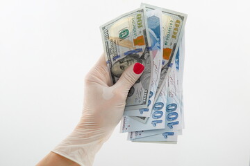 Covid 19 consept. In the pandemic days, the composition of the female hand, holding banknotes with hygienic gloves