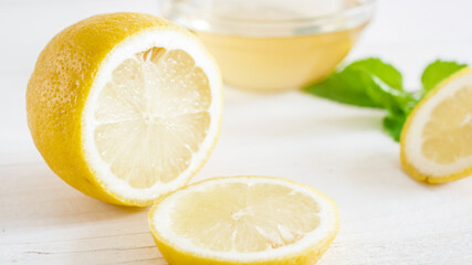 CLoseup photo of lemon half and slices lying on white wooden boards