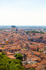 Fototapeta premium Aerial view of the historical center of Brescia (Lombardy, Italy) with tiled red roofs, chimneys, cathedral's domes and tall white brick old towers. Traditional European medieval architecture. 