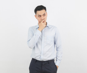 Young handsome asian business man thinking an idea while looking up isolated on white background.