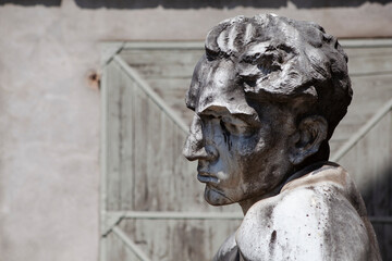 Close up. A statue of a man (a male head) made of white marble in a public park. Traditional European stone sculpture as an element of the interior. Vintage art