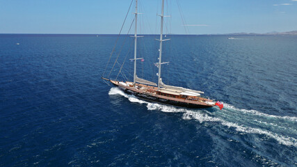 Aerial drone photo of beautiful sail boat with wooden deck sailing the Aegean deep blue sea, Greece
