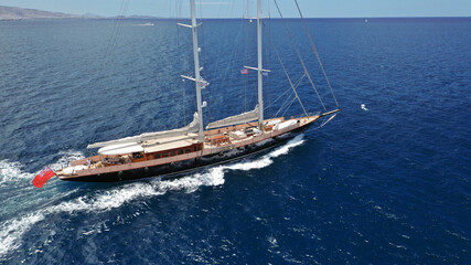 Aerial drone birds eye view of sail boat cruising in the deep blue Aegean sea, Greece