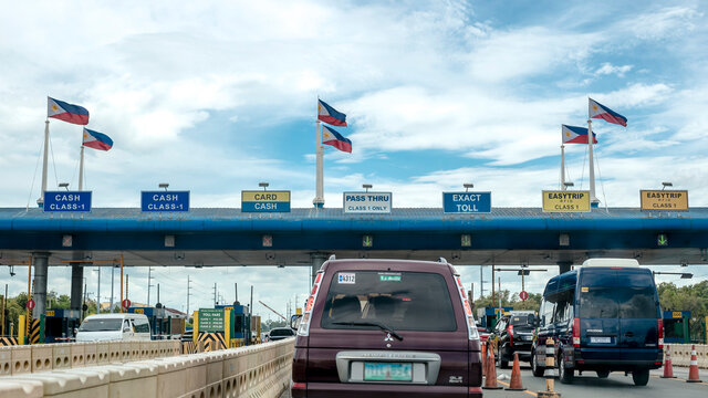 Paranaque, Metro Manila, Philippines: June 2020 - A Toll plaza at CAVITEx with a line of vehicles. Philippine Flags installed on top of Toll Plaza.