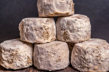 French cheese Crottin de Chavignol in the dark background