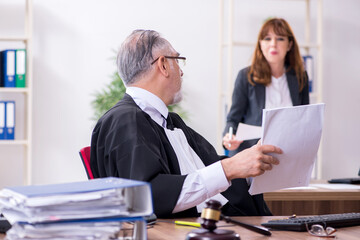 Old male judge and his young secretary in the office