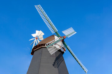 old wooden mill on a background of blue sky, historical architecture