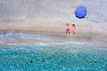 Ein junges Paar liegt am Strand der Kykladen und genießt den Sommer, Griechenland
