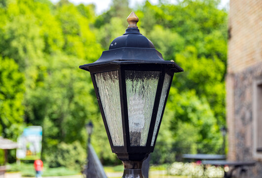 Old cast-iron lantern in a city park. Close-up. - Powered by Adobe