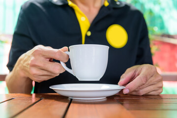 The man hold the hot green tea on his hand before drink / hot matcha