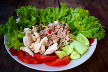 Fresh vegetable salad with meat on the wooden table background