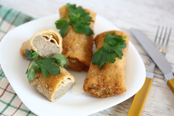 Croquettes with meat decorated with green parsley on white plate macro close up