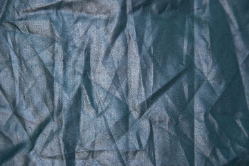Texture of crumpled dark blue synthetic fabric