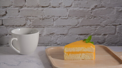 Orange cake and coffee on white stone table.