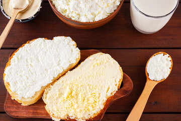 Dairy products. Milk, cottage cheese and sour cream in a rustic style. Bread with cream cheese on a wooden boards. Top view