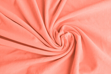 Coral pink delicate fabric draped and spun. Closeup.