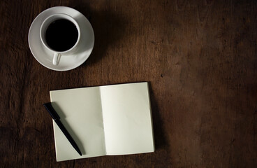 Cup of coffee, pen and notepad on wooden background.Home Office Desk concept. Top view.