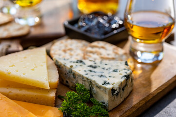 Whiskey and cheese pairing, tasting whisky glasses and plate with sliced cheeses