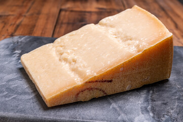 Big wedge of parmigiano-reggiano parmesan hard Italian cheese made from cow milk or Grana Padano