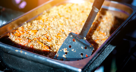 Cooking Uzbek pilaf on an open fire. Pilaf with meat, garlic, pepper, carrots. A large cauldron...