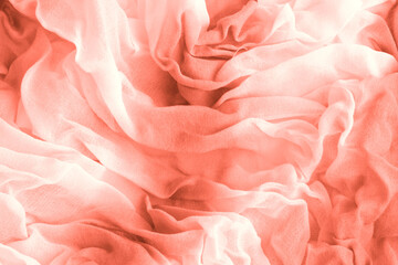 Texture of coral Wrinkled Fabric. Trendy color of clothes. Close-up.