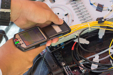 Internet technicians are measuring the optical signal using the Optical Fiber Identifier without...