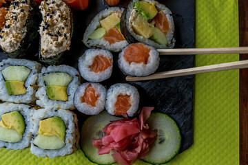 Eating with chopstick. Sushi set restaurant. Black background. Japanese sushi food. Healthy food. Top view. Food set.