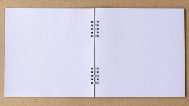 Stop motion book animation open white blank page for writing on wooden background.